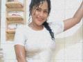 IvannaDuran with wet black curly hair, white tight shirt, showing small tits and wet skin, smiling in a tiled bathroom, raising one arm.