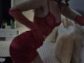 Rozalin in red lingerie with sheer cups, exposing her tits, and a short ruched skirt, wearing red gloves, leaning forward on a bed with white pillows.