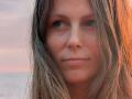 AuroraStar has dirty blonde, wet-looking hair covering her ears, with slightly flushed, pinkish skin and a subtle, closed-lip smile. She has blue eyes and a natural, relaxed look.