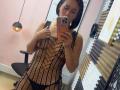 ScarlethFely with short black hair, wearing a black netted dress showing her tits and black panties, taking a mirror selfie with an orange phone.