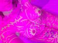 Bright pink and purple abstract digital art with swirling patterns and glowing highlights. MaddieLesYoux is partially visible, eyes closed, with a sensual, relaxed pose. Vibrant, energetic colors dominate.