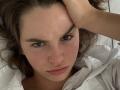 PeacHub69 has a serious face with slightly parted pink lips, brown wavy hair, and a hand touching their forehead. They're wearing a white shirt, looking pensive.