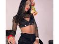 SexyHannaD with wavy black hair, wearing a black mesh crop top, showing her tits, and black high-waisted pants, red bracelet, and white wristband.