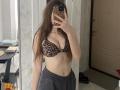 KaiaLein with long brown hair, wearing a leopard print bra that shows her tits and gray pants, taking a mirror selfie with a leopard phone case.