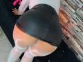 MeganHotCole is bent over, wearing a tight black leather skirt that's pulled up to expose her big, bare ass and white thigh-high stockings.