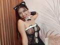 BrendaaPierce with black lace lingerie, cat ears, and a bowtie, smiling, showing her tits, with one hand on her face, in a sexy, playful pose.