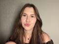 DeborahHaughey has long brown hair, light skin, and is making a pouty face with her lips slightly curled. She's wearing an off-shoulder black top with a small necklace.
