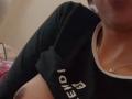 MyaaTyler's dark skin, showing her black shirt with white text, and a gold necklace, with a visible nipple on her left side. Her shirt is lifted slightly.