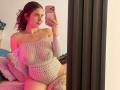 ValeryScot with curly red hair, off-shoulder white knit sweater, showing her tits and ass, holding a pink phone, tattoos on her thigh, sitting in front of a mirror.