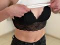 Sanella's hands are lifting a white shirt, exposing her black lace bra that covers her tits. She's wearing black jeans, showing a bit of her bare midriff.