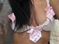 AndraD's tits in a pink polka-dot, ruffled, white bra with small pink bows. She's got long black hair and a tattoo on her right arm.