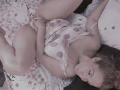 AmberDemons is lying on a bed, wearing a polka dot lingerie top, exposing her tits and pussy, with her legs spread, holding her pussy, and looking at the camera.