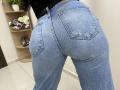 OliviaGranda's denim-clad ass is centered, showing tight, blue, jean pockets and a black top, with her back to the camera, in a brightly lit room.